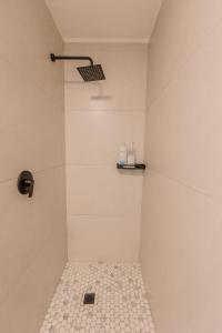 a bathroom with a shower with a tiled floor at The Stay Edit Windhoek in Windhoek +37 photos