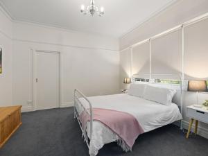a white bedroom with a bed and a desk at The Gables in Marysville