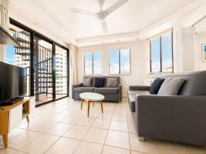 a living room with two couches and a tv at Stylish 1 Bedroom with Private Rooftop Spa at the Aegean in Mooloolaba