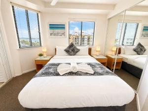 a bedroom with a large bed with a bow on it at Stylish 1 Bedroom with Private Rooftop Spa at the Aegean in Mooloolaba +9 photos
