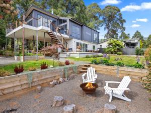 a house with two white chairs and a fire pit at The Nest on Hull in Marysville