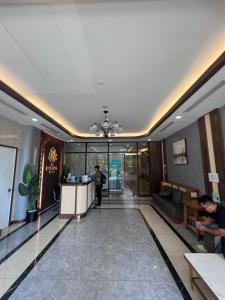 a lobby of a hotel with a man standing at a counter at MH Home in Long Bình