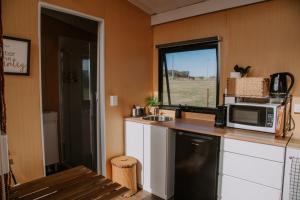 a kitchen with a microwave and a sink and a window at Tiny Boorowa by Tiny Away in Boorowa +25 photos