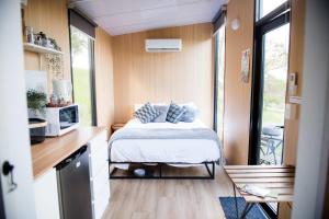 a small bedroom with a bed in a tiny house at Tiny Inja 2 by Tiny Away in Comleroy