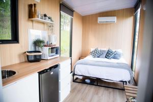 a small kitchen with a bed in a tiny house at Tiny Inja 2 by Tiny Away in Comleroy