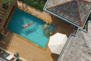 an overhead view of two people swimming in a pool at Rawayana Villas in Rawai Beach +36 photos