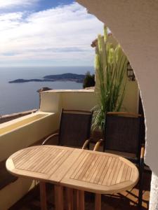 d'une table et de chaises sur un balcon avec vue sur l'océan. dans l'établissement Eze Monaco middle of old town of Eze Vieux Village Romantic Hideaway with spectacular sea view, à Èze