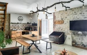 a living room with a table and a tv at Grange En Campagne in Vauxaillon