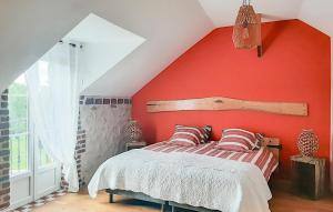 a bedroom with a red wall and a bed with pillows at Grange En Campagne in Vauxaillon
