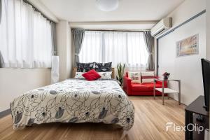 a bedroom with a bed and a red chair at ESPERANZA103 広い綺麗快適高速WiFi in Tokyo
