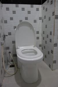 a bathroom with a white toilet in a room at AHHA Residence Kampot in Phumĭ Bœ̆ng Phlŏng (2)