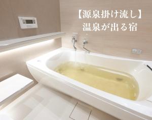 a bath tub in a bathroom with writing on the wall at NAGASHIMA clas in Kuwana
