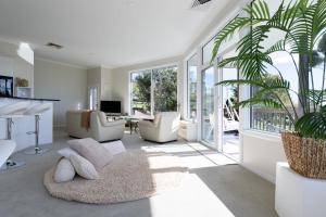 a living room with white furniture and a large window at Tamar River Hideaway in Legana