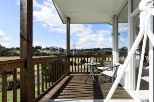 a wooden porch with a table and chairs on it at Tamar River Hideaway in Legana