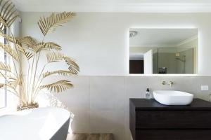 a bathroom with a sink and a palm tree in it at Tamar River Hideaway in Legana +28 photos