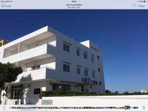 a white building with a sign on it at Apartamentos Alba in San Antonio Bay