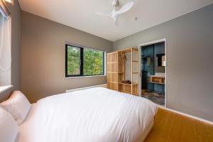 a bedroom with a large white bed and a window at COCO VILLA ニセコアンヌプリ-Niseko Annupuri in Rankoshi