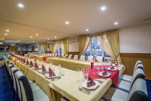 a row of tables in a restaurant with red napkins at Hotel Sun in Senec +140 photos