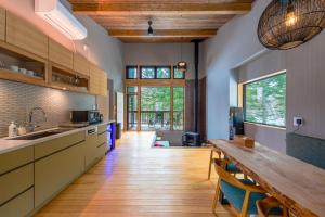 a kitchen with a wooden table and a wooden floor at COCO VILLA ニセコアンヌプリ-Niseko Annupuri in Rankoshi