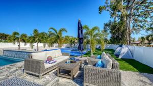 a patio with chairs and an umbrella next to a pool at Stay & Play Sarasota in Sarasota