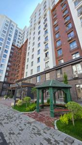 a green bench in front of a building at Residence Apartment Osh Шикарные апартаменты в самом Элитном районе города Ош in Osh