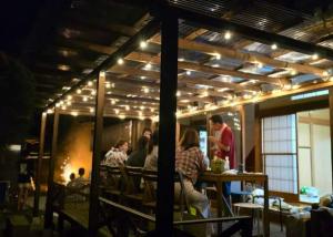 a group of people sitting at a table in a restaurant at 古民家松 in Isumi