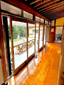an empty room with glass doors and a wooden floor at 古民家松 in Isumi +20 photos