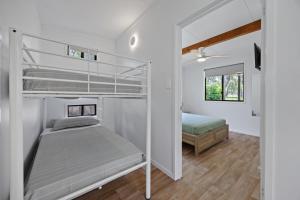 a small bedroom with a bunk bed and a bed at Agnes Bush Cabins in Agnes Water