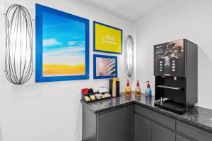 a kitchen with a counter with a tv and a refrigerator at Days Inn by Wyndham San Francisco S/Oyster Point Airport in South San Francisco