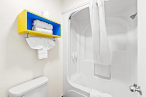 a bathroom with a shower and a toilet and towels at Days Inn by Wyndham San Francisco S/Oyster Point Airport in South San Francisco +21 photos