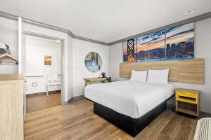 a hotel room with a bed and a desk at Days Inn by Wyndham San Francisco S/Oyster Point Airport in South San Francisco