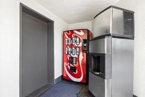a coca cola refrigerator in a room with a door at Days Inn by Wyndham San Francisco S/Oyster Point Airport in South San Francisco