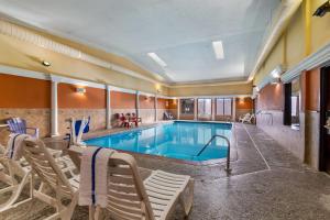 a pool in a hotel room with chairs around it at Days Inn by Wyndham Minot in Minot