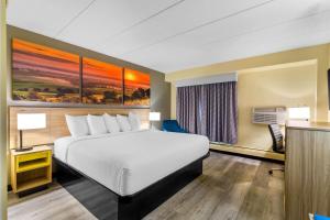 a hotel room with a bed and a desk at Days Inn by Wyndham Minot in Minot +40 photos