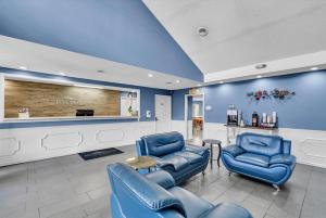 a waiting room with blue chairs and a counter at Baymont by Wyndham Warner Robins in Warner Robins