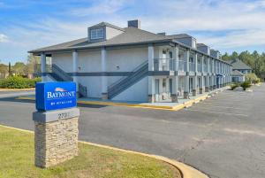 a building with a blue sign in front of it at Baymont by Wyndham Warner Robins in Warner Robins