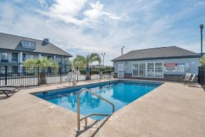 a swimming pool in front of a building at Baymont by Wyndham Warner Robins in Warner Robins