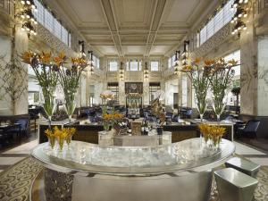 a lobby with a large room with tables and chairs at Park Hyatt Vienna in Vienna