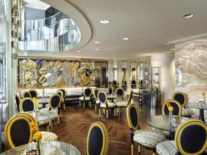 a restaurant with tables and chairs and a large mirror at Park Hyatt Vienna in Vienna