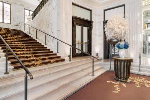 a lobby with stairs and a vase of flowers at Park Hyatt Vienna in Vienna