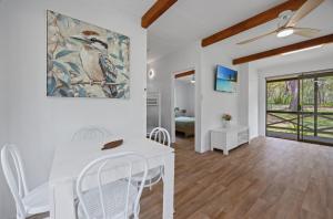 a dining room with a white table and chairs at Agnes Bush Cabins in Agnes Water