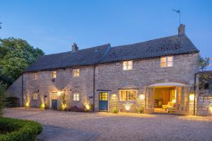 an old stone house with christmas lights on it at River Nene Cottages in Water Newton