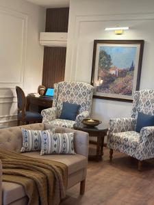 a living room with a couch and chairs and a piano at The Row House Kasauli in Kasauli