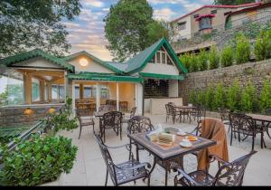 a patio with tables and chairs and a building at The Row House Kasauli in Kasauli