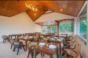 an empty restaurant with wooden tables and chairs at The Row House Kasauli in Kasauli +12 photos