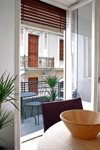 een kamer met een balkon met een tafel en stoelen bij Bauhaus building with green roof top terrace - EP16 in Athene