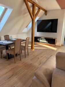 a living room with a table and a large tv at Apartament Wypoczynkowy Centrum in Tuchola