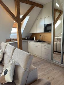 a living room with a couch and a kitchen at Apartament Wypoczynkowy Centrum in Tuchola