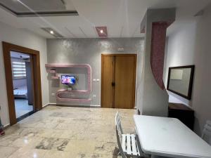 a room with a table and a tv on a wall at Studio de vacance à louer in Monastir