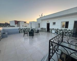 a balcony with chairs and tables on a building at Studio de vacance à louer in Monastir